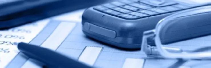 Phone, glasses, and pen on financial documents.